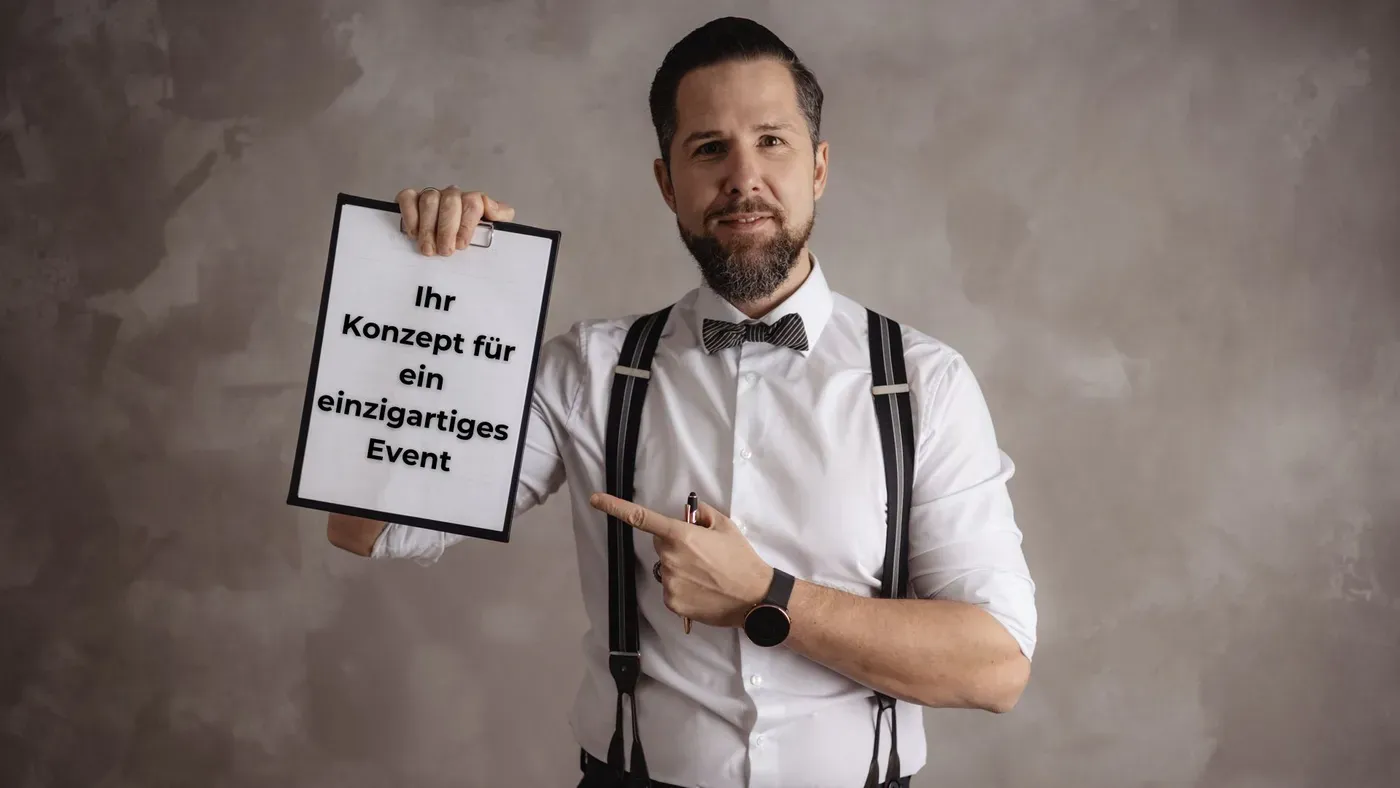 Stefan Kramberg hält ein Schild: Ihr Konzept für ein einzigartiges Event