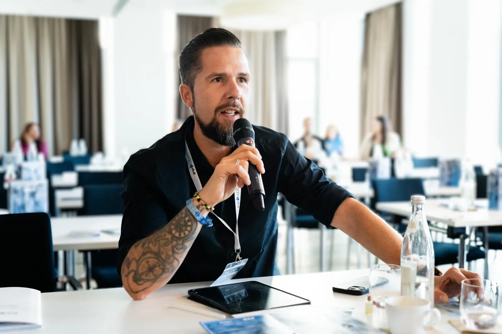 Moderator Stefan Kramberg spricht mit Mikrofon bei einer Konferenz
